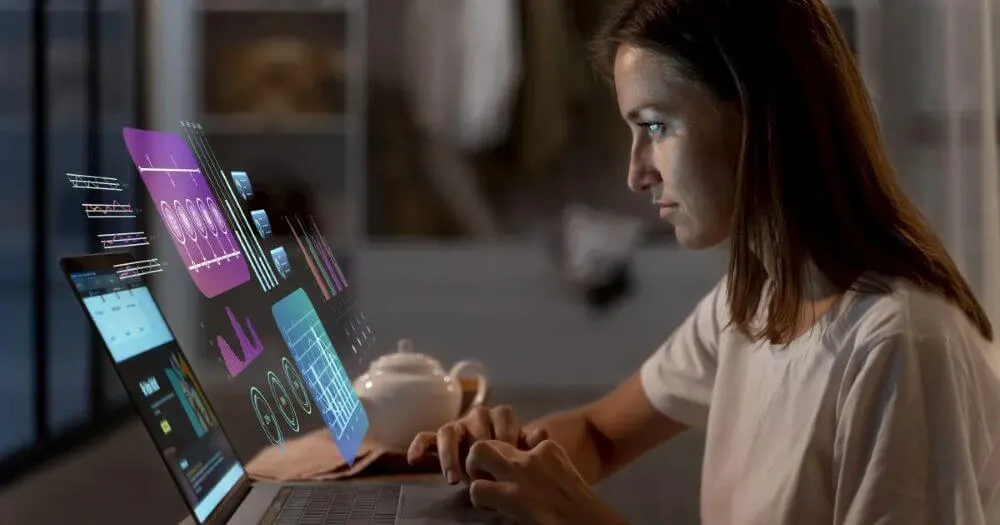 Mulher trabalhando no notebook analisando gráficos flutuantes de inteligência artificial e ciência de dados à noite.